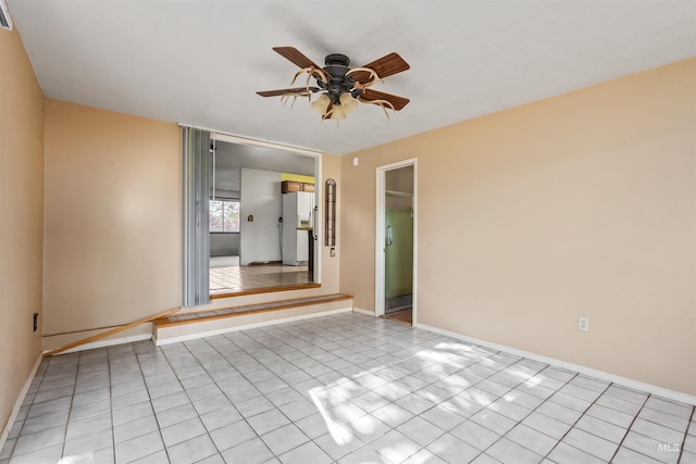 spare room with light tile patterned flooring, ceiling fan, visible vents, and baseboards