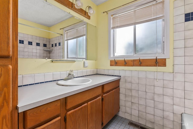 3709 11th St, Lewiston, ID 83501 - full bathroom with tile walls, visible vents, plenty of natural light, and vanity