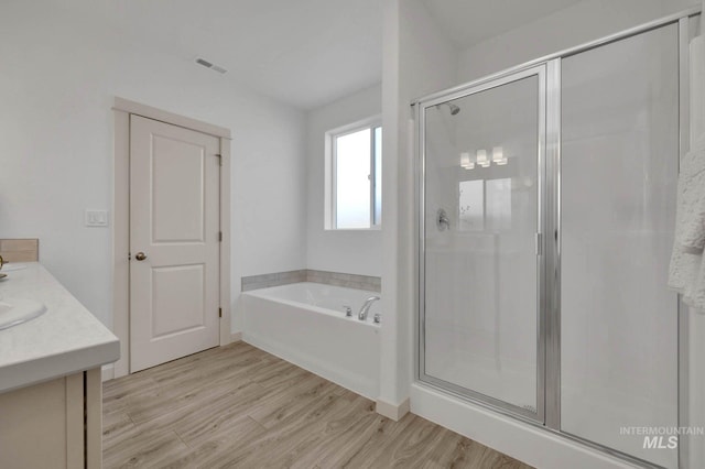 17869 N Onaway Ave, Nampa, ID 83686 - bathroom with a stall shower, wood finished floors, a garden tub, and vanity