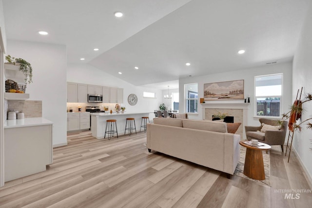 17869 N Onaway Ave, Nampa, ID 83686 - living area with light wood-type flooring, a fireplace, vaulted ceiling, recessed lighting, and baseboards