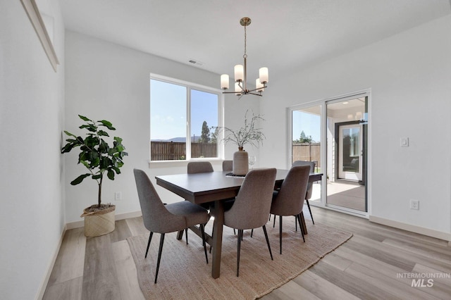 17869 N Onaway Ave, Nampa, ID 83686 - dining room featuring a chandelier, light wood-style floors, and baseboards