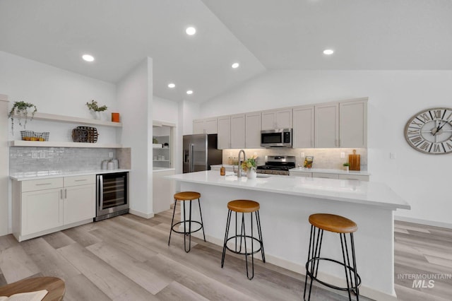 17869 N Onaway Ave, Nampa, ID 83686 - kitchen featuring stainless steel appliances, beverage cooler, a sink, a kitchen bar, and tasteful backsplash
