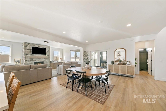 dining space featuring recessed lighting, light wood-style flooring, a fireplace, and baseboards