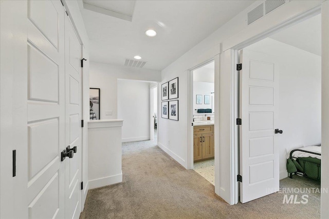 hall featuring recessed lighting, visible vents, baseboards, and light carpet