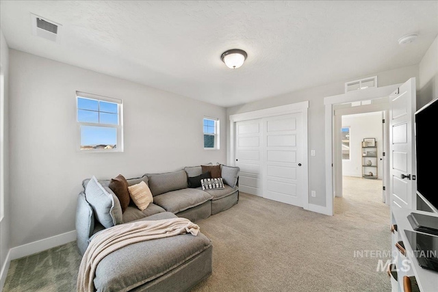 living room featuring visible vents, baseboards, and carpet