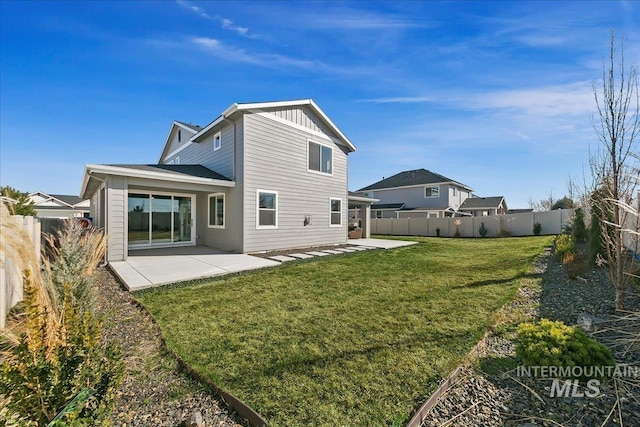 rear view of property featuring board and batten siding, a lawn, a fenced backyard, and a patio