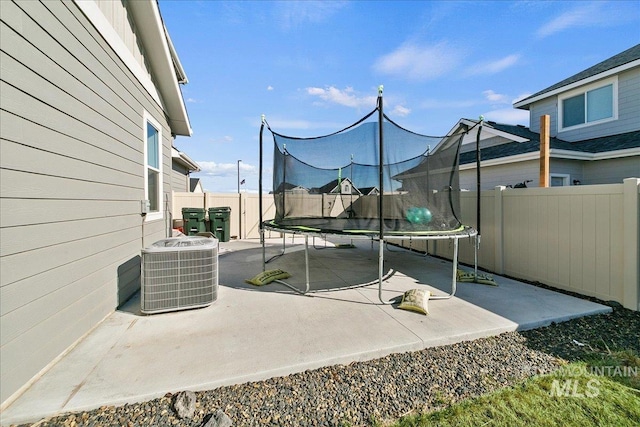 view of patio / terrace featuring central AC, a fenced backyard, and a trampoline