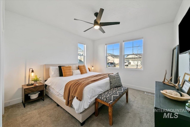 carpeted bedroom featuring baseboards and ceiling fan
