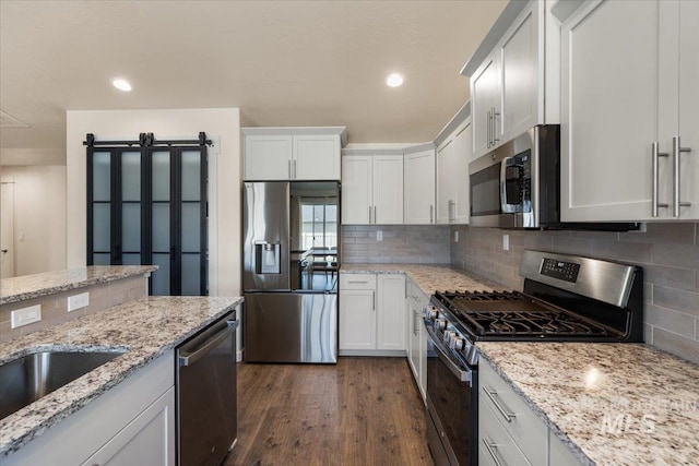 7682 W Itasco Dr, Boise, ID 83709 - kitchen with stainless steel appliances, decorative backsplash, dark wood-style flooring, white cabinetry, and recessed lighting