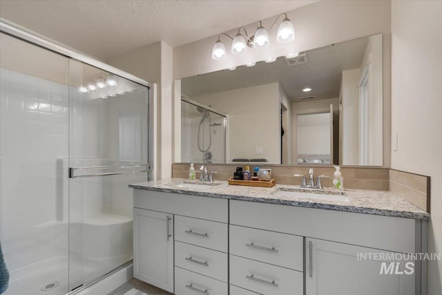 7682 W Itasco Dr, Boise, ID 83709 - bathroom featuring double vanity, a stall shower, and a textured ceiling