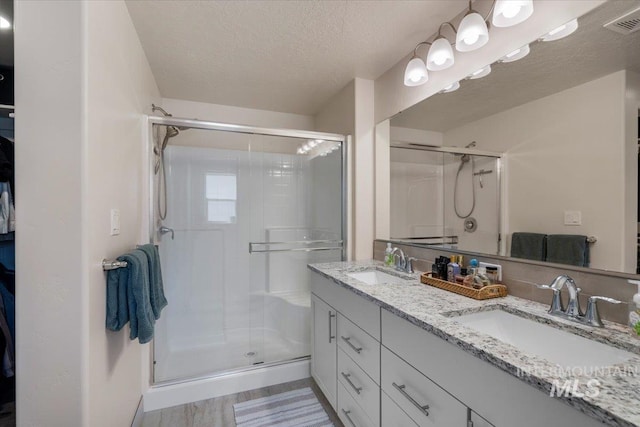 7682 W Itasco Dr, Boise, ID 83709 - full bath with a shower stall, a textured ceiling, and double vanity
