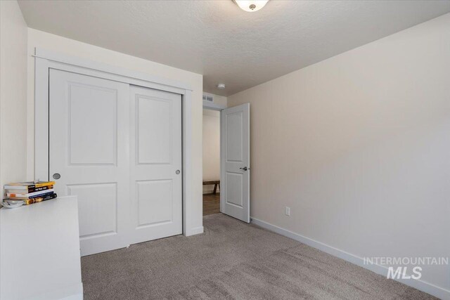 7682 W Itasco Dr, Boise, ID 83709 - unfurnished bedroom featuring carpet floors, baseboards, a closet, and a textured ceiling