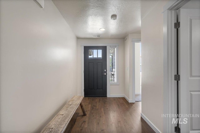 7682 W Itasco Dr, Boise, ID 83709 - foyer entrance with dark wood-style flooring, a textured ceiling, and baseboards