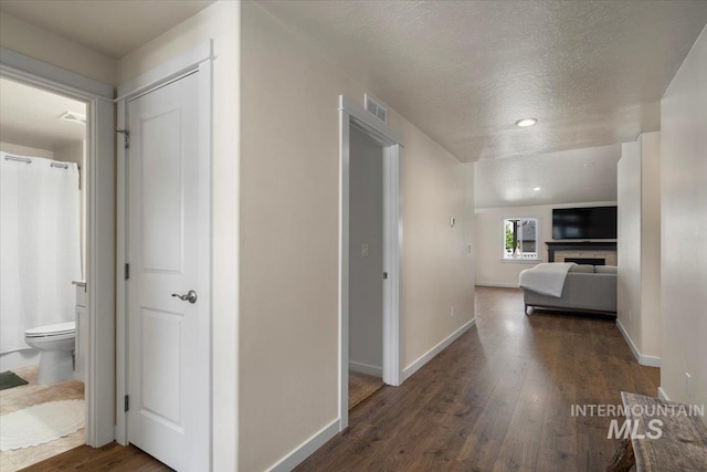 7682 W Itasco Dr, Boise, ID 83709 - corridor with wood finished floors, a textured ceiling, and baseboards