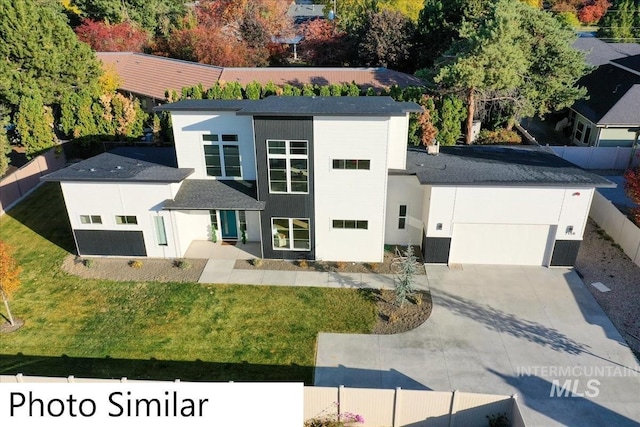 contemporary house with a garage, fence, a front lawn, and concrete driveway