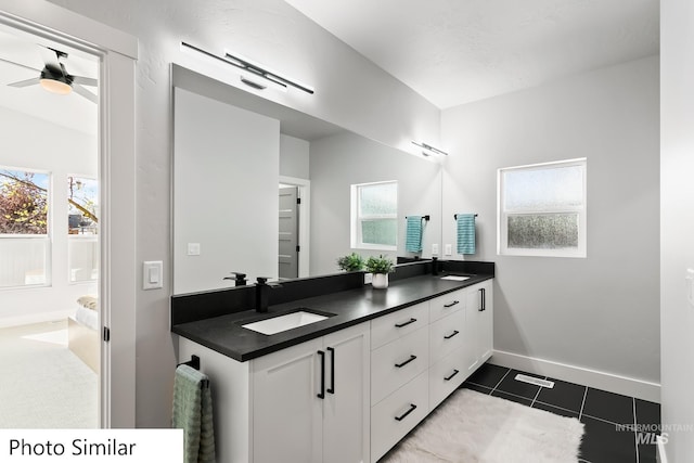 bathroom with a healthy amount of sunlight, tile patterned flooring, double vanity, and a sink