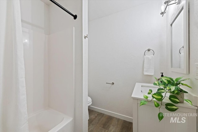 5805 W Robertson Dr, Boise, ID 83709 - full bath featuring toilet, baseboards, wood finished floors, shower / tub combo with curtain, and vanity