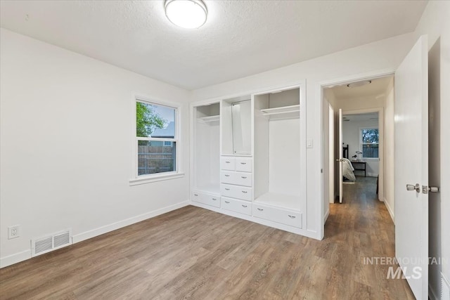 5805 W Robertson Dr, Boise, ID 83709 - unfurnished bedroom with a textured ceiling, baseboards, visible vents, wood finished floors, and a closet