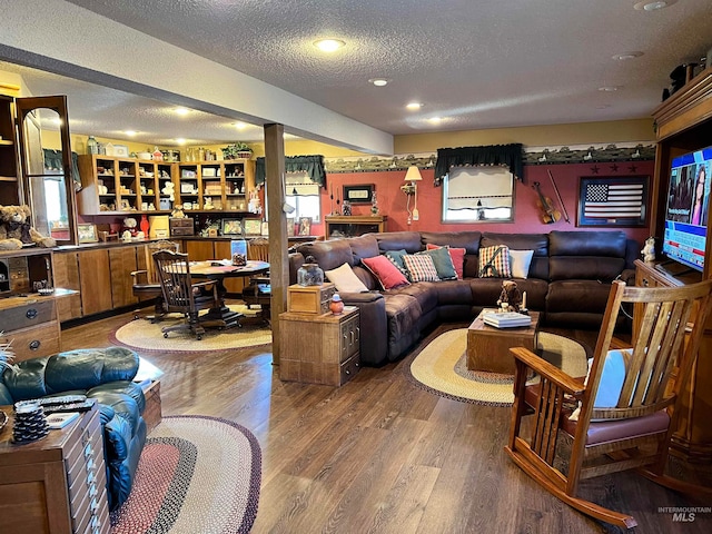 living room featuring plenty of natural light, a textured ceiling, and dark hardwood / wood-style floors