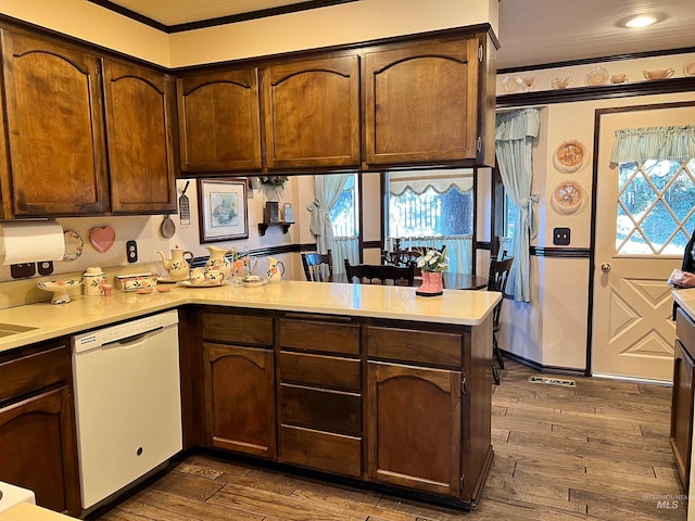 kitchen with ornamental molding, dark brown cabinets, dishwasher, and dark hardwood / wood-style flooring