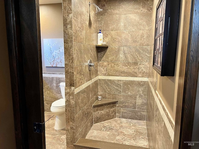 bathroom with toilet and tiled shower