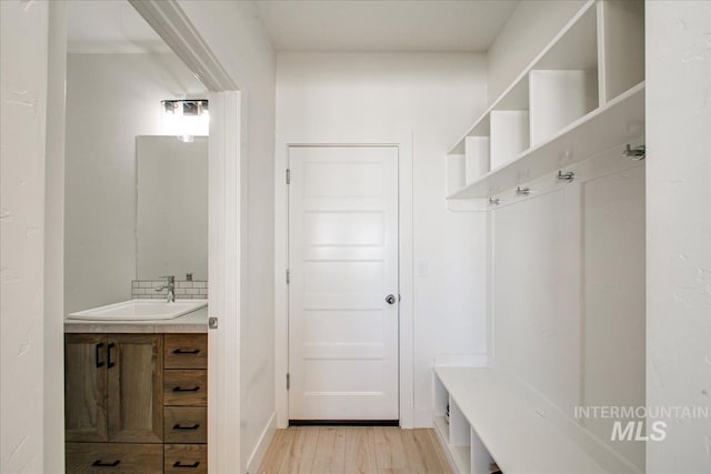 mudroom with light wood-style flooring and a sink