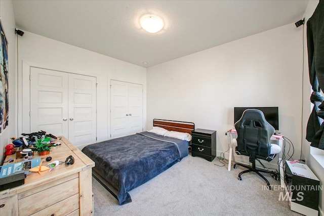 bedroom with carpet and two closets