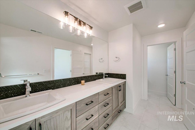 bathroom with visible vents, a sink, and marble finish floor
