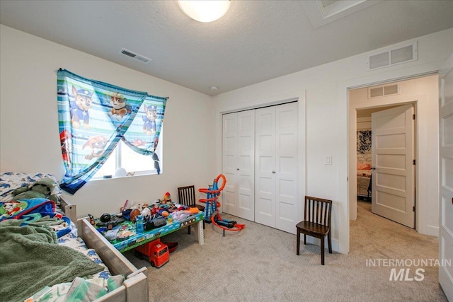 playroom with light colored carpet, a textured ceiling, and visible vents