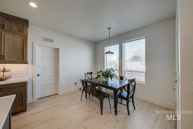 dining room with baseboards, light wood finished floors, visible vents, and recessed lighting
