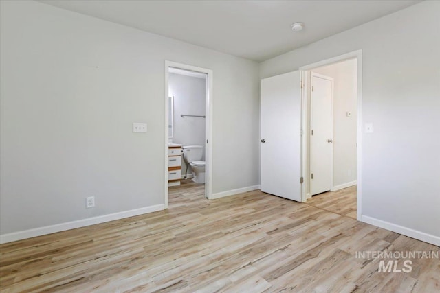 2285 S Challenger Unit 201, Boise, ID 83705 - unfurnished bedroom featuring wood finished floors, baseboards, and ensuite bath