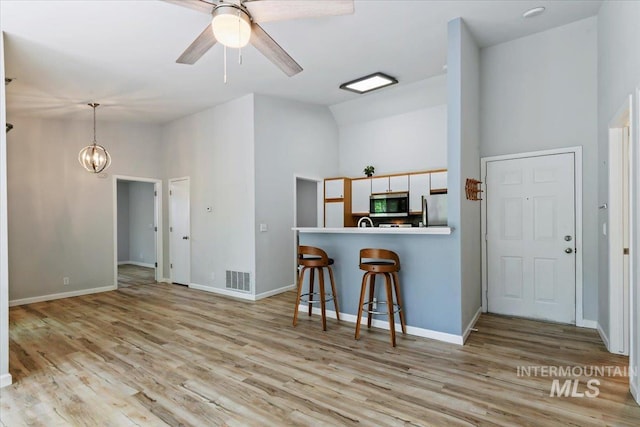2285 S Challenger Unit 201, Boise, ID 83705 - kitchen with stainless steel appliances, high vaulted ceiling, a ceiling fan, light wood-style floors, and a breakfast bar area