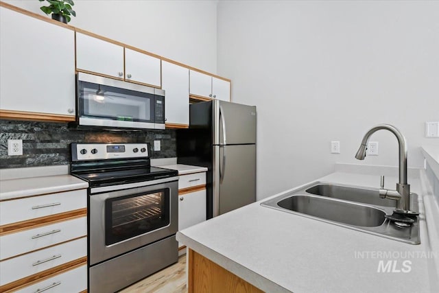 2285 S Challenger Unit 201, Boise, ID 83705 - kitchen featuring stainless steel appliances, a sink, tasteful backsplash, and white cabinets