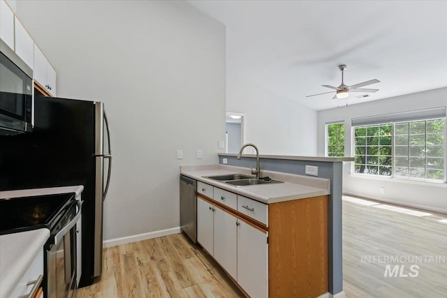 2285 S Challenger Unit 201, Boise, ID 83705 - kitchen featuring a sink, a peninsula, stainless steel appliances, light wood-type flooring, and white cabinets