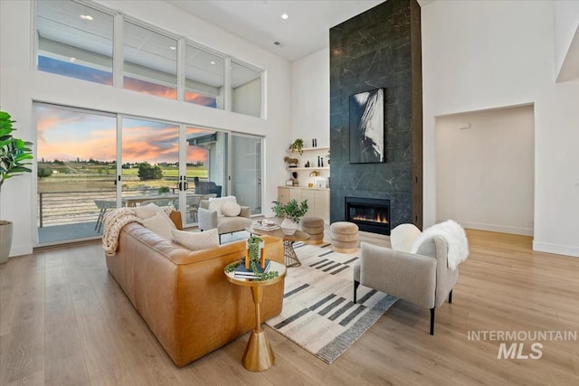 12975 Shasta Daisy Way, Nampa, ID 83686 - living room with a high ceiling, baseboards, light wood-type flooring, a premium fireplace, and recessed lighting