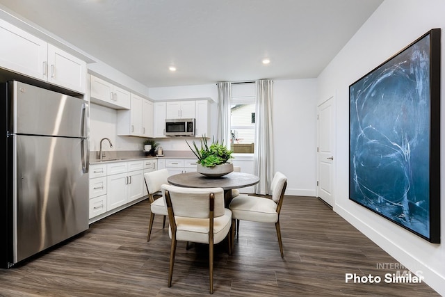 kitchen with white cabinets, stainless steel appliances, dark wood-type flooring, and sink