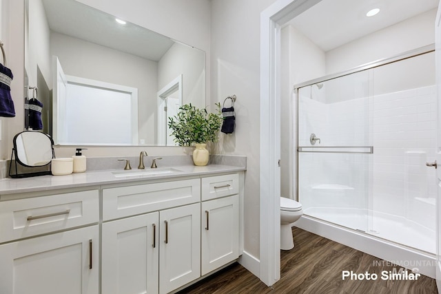 bathroom with walk in shower, toilet, vanity, and hardwood / wood-style flooring