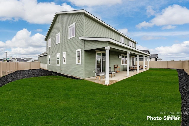 back of house featuring a lawn and a patio area