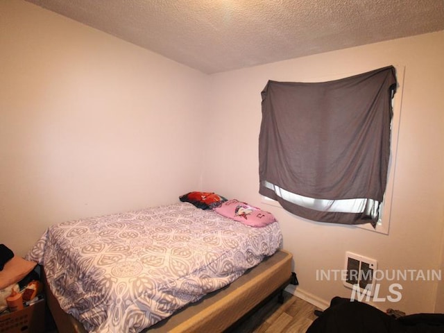 210 W 2nd St, Middleton, ID 83644 - bedroom with wood finished floors and a textured ceiling