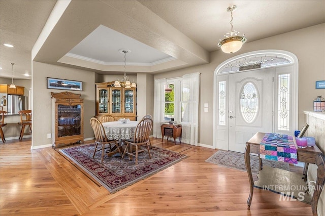 10395 Willis Rd, Middleton, ID 83644 - entryway with a tray ceiling, a notable chandelier, light wood-type flooring, and baseboards