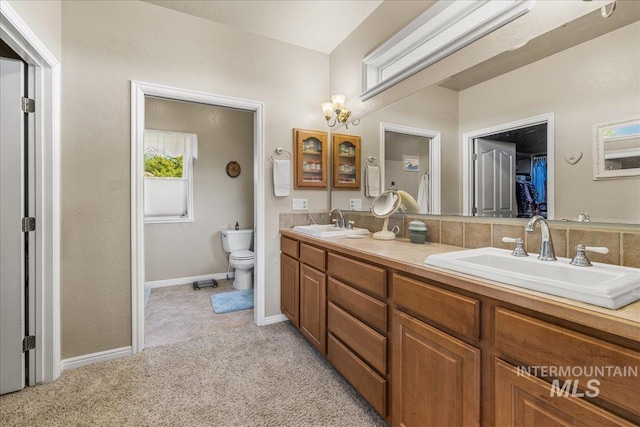 10395 Willis Rd, Middleton, ID 83644 - bathroom featuring a sink, double vanity, toilet, and baseboards