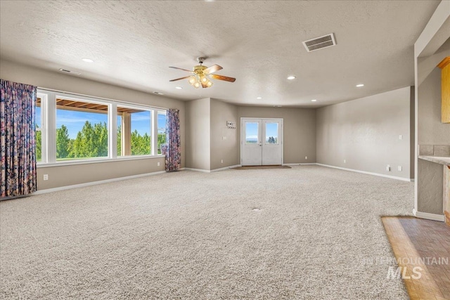 10395 Willis Rd, Middleton, ID 83644 - unfurnished living room featuring light colored carpet, a textured ceiling, recessed lighting, ceiling fan, and baseboards