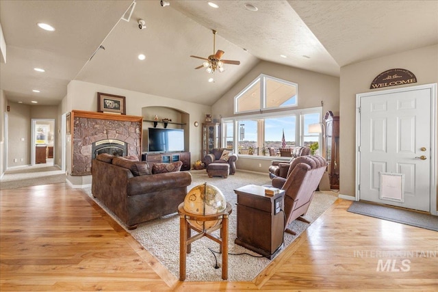 10395 Willis Rd, Middleton, ID 83644 - living room featuring light wood finished floors, vaulted ceiling, a fireplace, and a ceiling fan