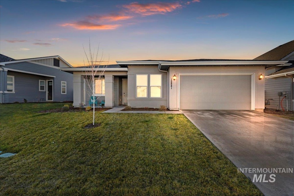 view of front of house featuring a garage and a yard