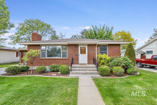 357 Pierce St, Twin Falls, ID 83301 - view of front of home with a chimney, a front yard, and brick siding