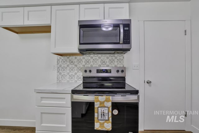 357 Pierce St, Twin Falls, ID 83301 - kitchen featuring stainless steel appliances, white cabinetry, decorative backsplash, light countertops, and wood finished floors