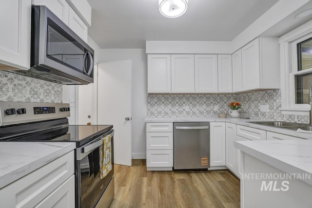 357 Pierce St, Twin Falls, ID 83301 - kitchen with appliances with stainless steel finishes, white cabinetry, light wood-style flooring, and light stone countertops