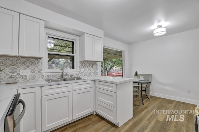 357 Pierce St, Twin Falls, ID 83301 - kitchen featuring a sink, white cabinets, light countertops, and tasteful backsplash