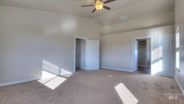 unfurnished bedroom with high vaulted ceiling, baseboards, and light colored carpet