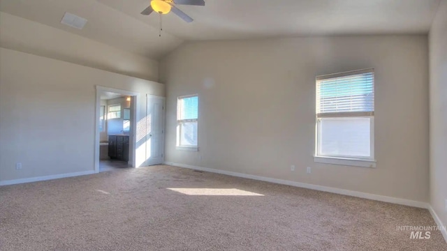 carpeted empty room featuring lofted ceiling, ceiling fan, and baseboards